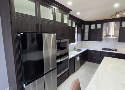 A dark cabinets with white and gray countertop kitchen renovation project completed by Titan Cabinetry