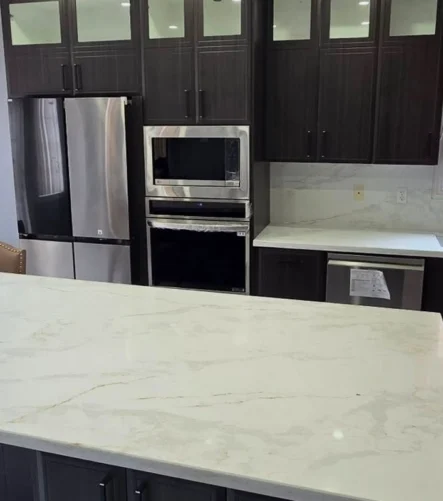 A dark cabinets with white and gray countertop kitchen renovation project completed by Titan Cabinetry